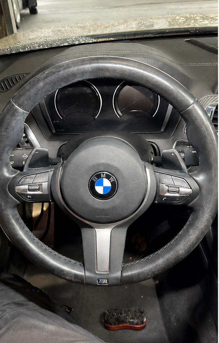 Verschmutztes BMW Lenkrad mit abgegriffenem Leder vor der Innenreinigung